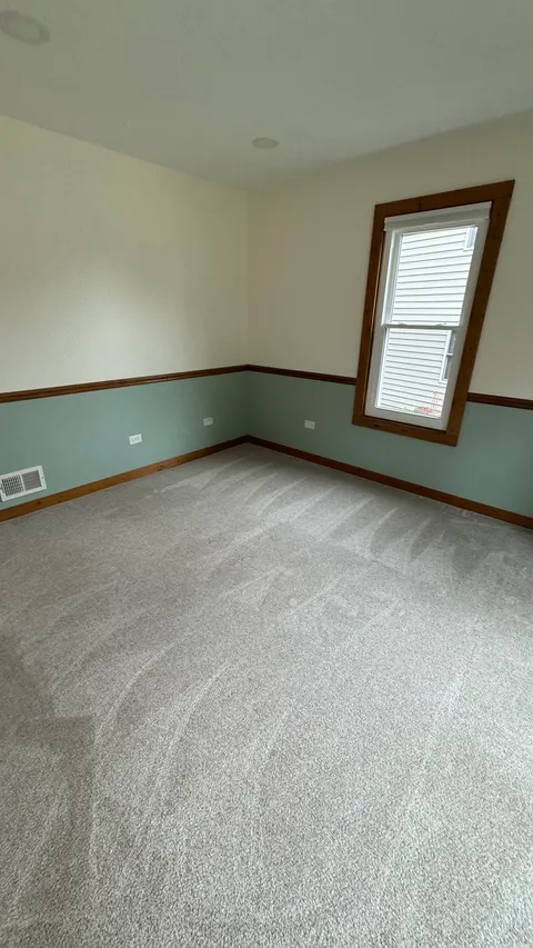 Bedroom with vacuumed carpet, wiped baseboards and clean window trim