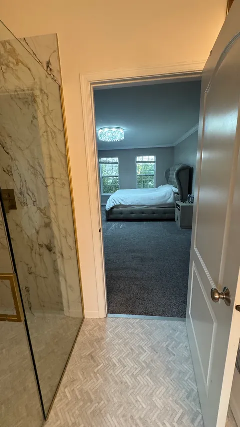 Freshly vacuumed bedroom carpet seen through a spotless bathroom doorway