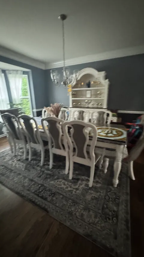 Formal dining room with dusted table chairs and hutch after cleaning