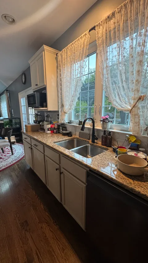 Wiped-down kitchen counters cabinets and hardwood floor after a full clean