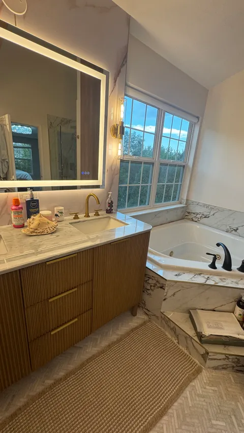 Marble vanity countertop and soaking tub after a detailed bathroom cleaning
