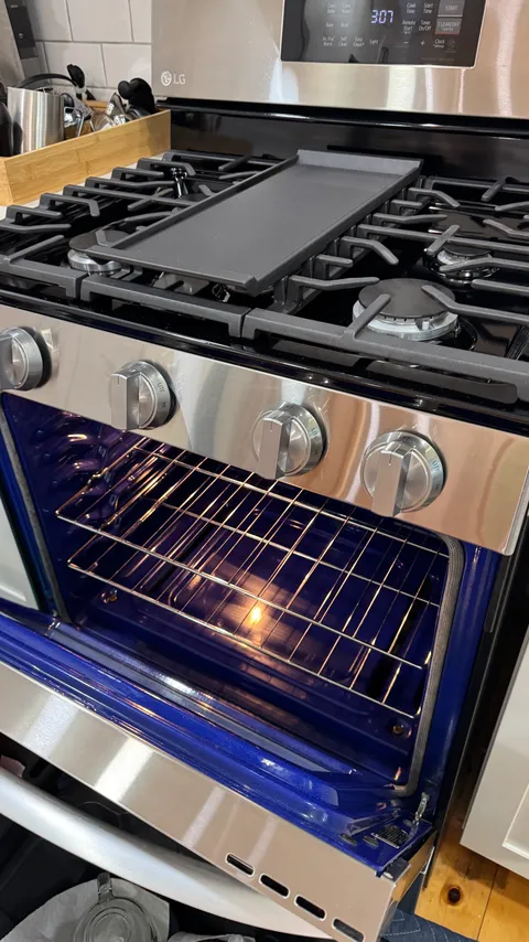 Open oven with a scrubbed interior and freshly cleaned baking racks