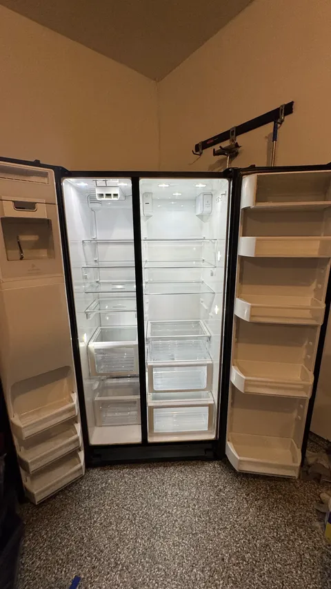 Refrigerator interior with wiped-down shelves, bins and door racks after a deep clean