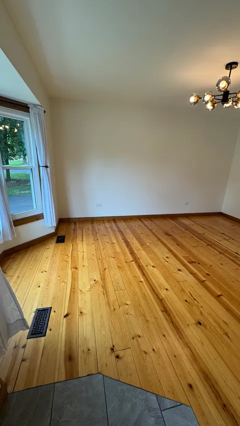 Freshly cleaned room with polished pine floors, clean vents and bright white walls