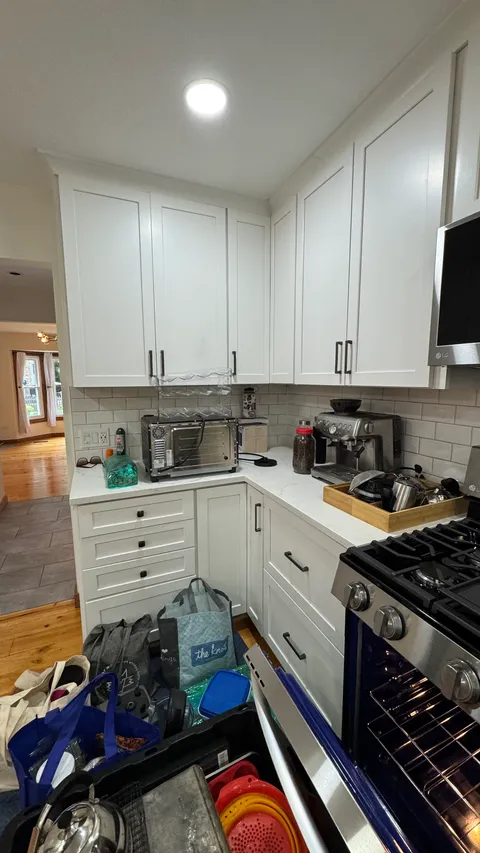 Kitchen corner with dusted white cabinets and wiped quartz countertops