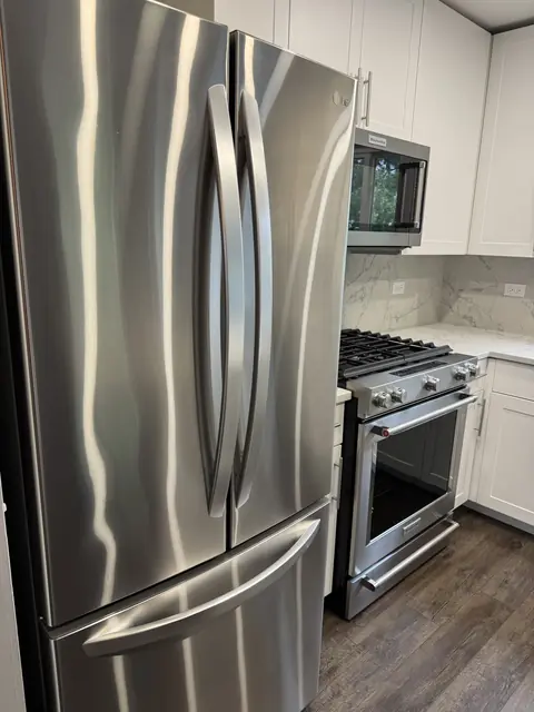 Polished stainless steel refrigerator and range in a professionally cleaned kitchen
